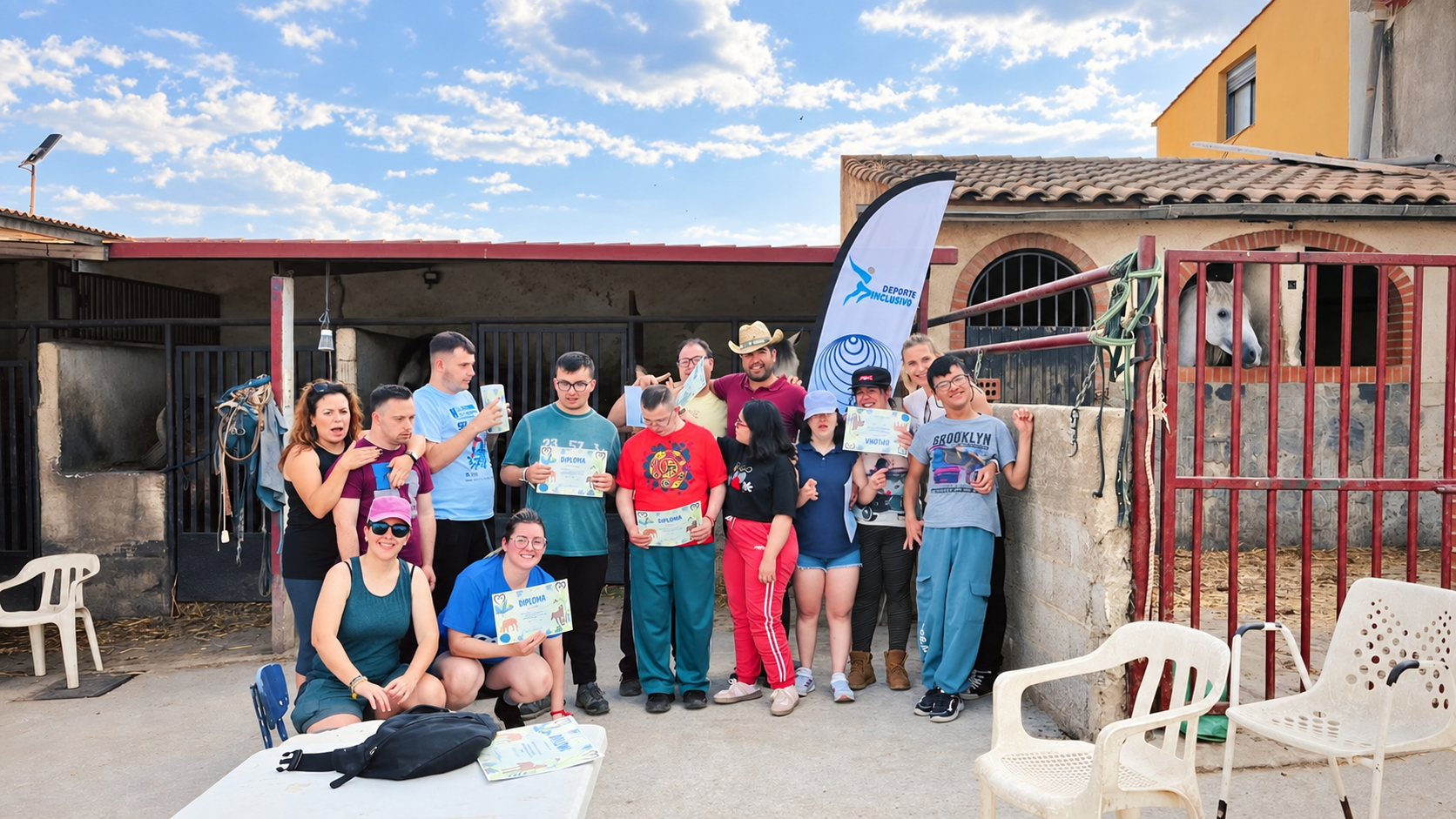Participantes y equipo posan con sus diplomas al finalizar una actividad con caballos